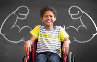 boy in wheelchair in front of muscle arm chalk board